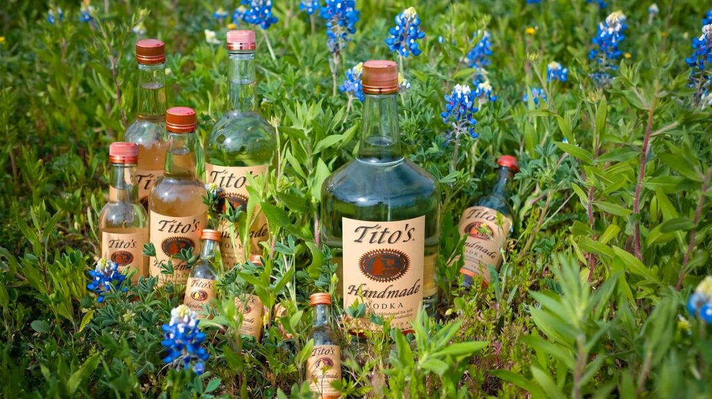 Tito's Vodka laying in grass